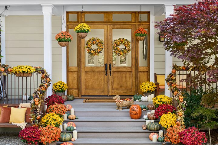  门廊上装饰着五颜六色的秋天花环、花圈和瓮填料