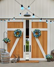 Spring porch décor with wreaths, pot fillers, and lights