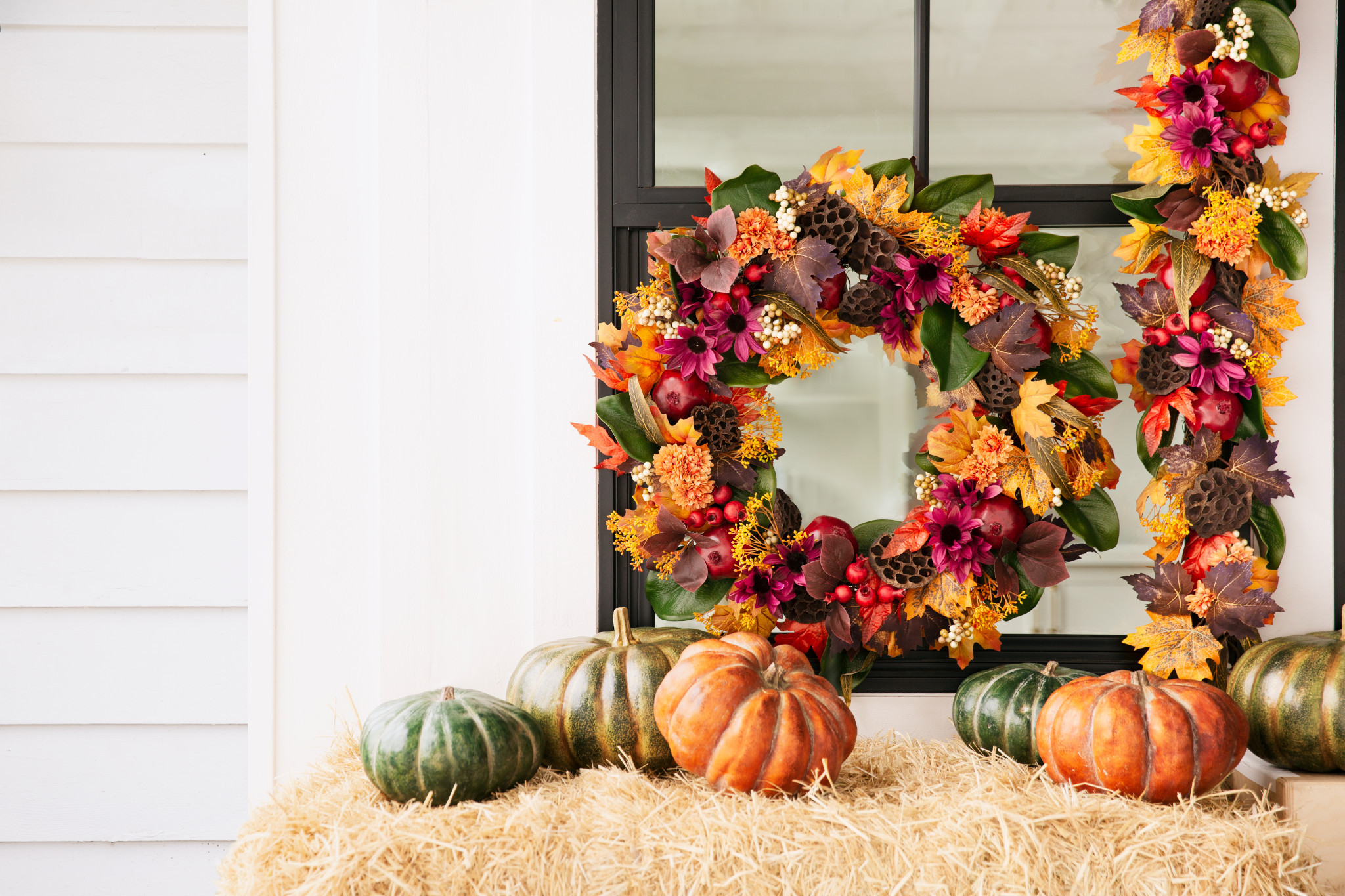 Outdoor Thanksgiving decoration idea with multicolor wreath, garland, and pumpkins