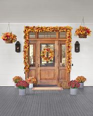 Front porch décor idea with autumn wreaths, garlands, and urn fillers