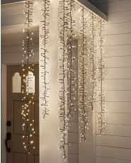 Cascading Christmas lights on the side of a white porch