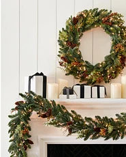 Flameless candles, wreath, and garland on mantel