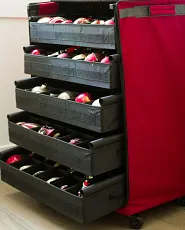 A red and black storage cart filled with various colorful Christmas ornaments ready for holiday decorating