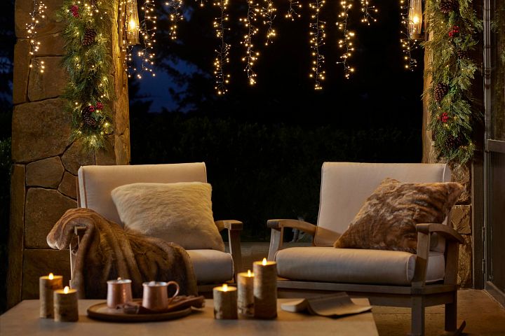 Patio chairs decorated with faux fur throw pillows and blankets
