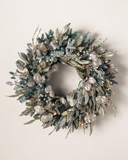 Artificial Christmas wreath with lightly flocked needles and decorated with champagne and crystal accents