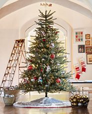 Schlichter künstlicher Weihnachtsbaum mit roten und goldenen Kugeln