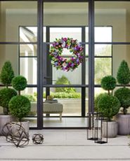 Spring front porch with a wreath and topiaries
