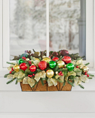 Artificial Christmas greenery with ornaments in a window box