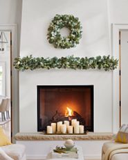Fireplace mantel decorated with artificial Christmas wreath and garland