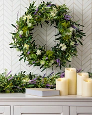 Mantel décor idea with flower wreath, garland, LED candles, and book