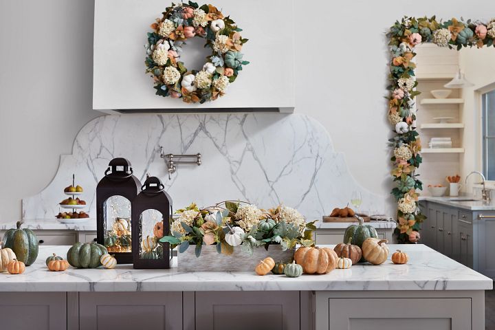 White kitchen interior with pumpkins and fall foliage decor