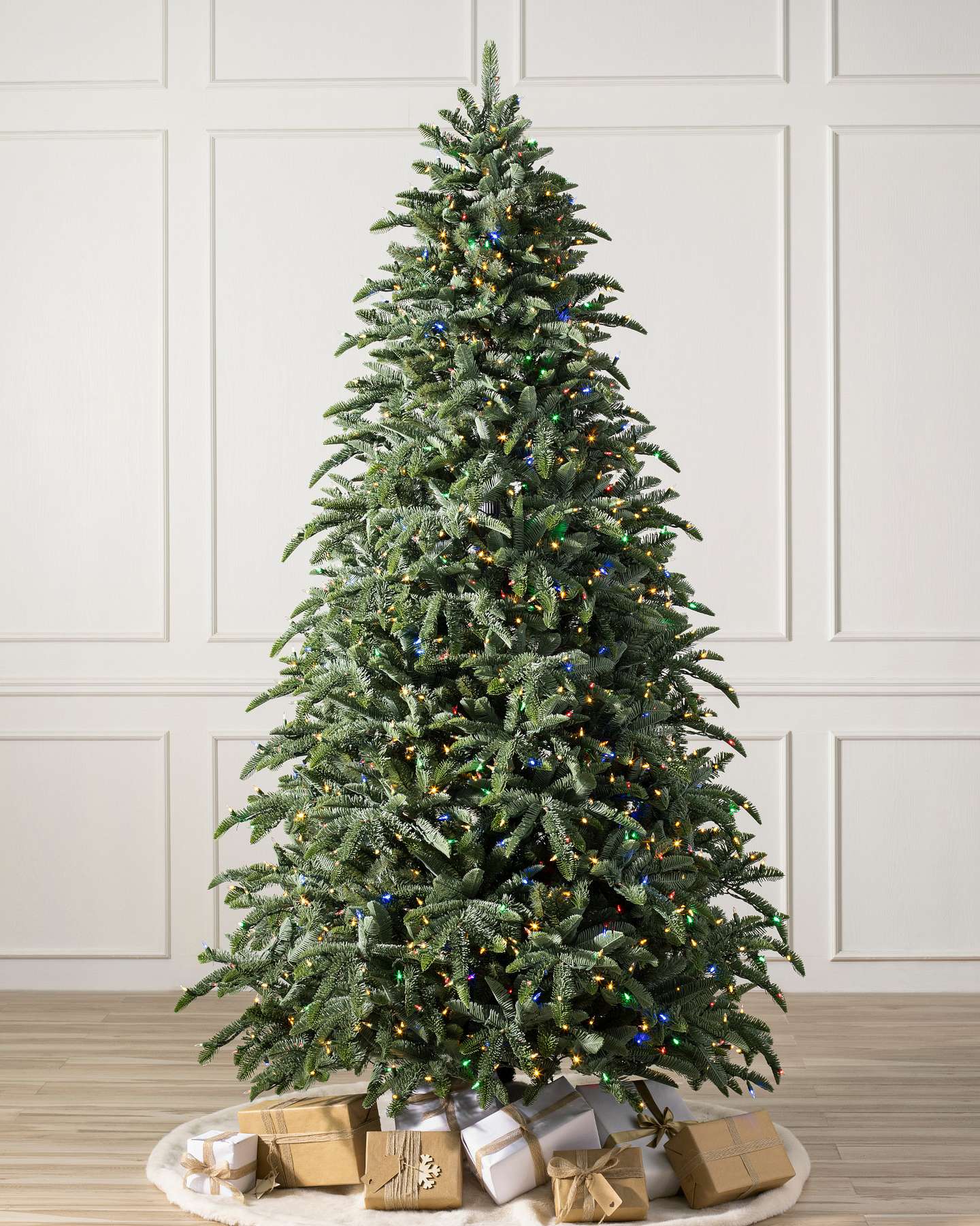 Balsam Hill Noble Fir Narrow Artificial Christmas Tree with LED Lights in Studio Setting