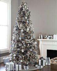 In grauen und silbernen Metallic-Farben dekorierter künstlicher Weihnachtsbaum mit Schnee