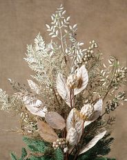 Bouquet tree topper with champagne-colored magnolia flowers, berries, and mixed leaves