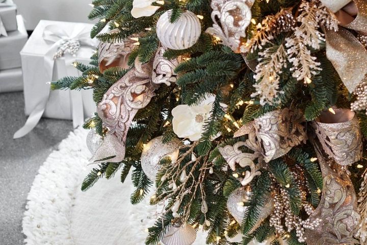 Plan rapproché d'un sapin de Noël décoré de rubans et de guirlandes or et champagne