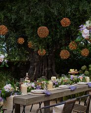 Outdoor dining area decorated with artificial flower garland