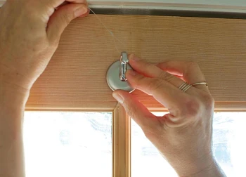 Woman tying nylon cord from adhesive hook on door