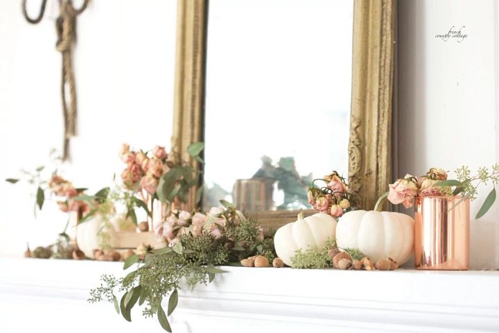 Mantel decorated with white pumpkins, garlands, and a copper mug