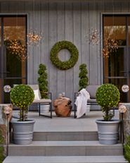A patio decorated with wreaths and garlands