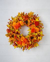 Fall décor wreath with mums, sunflowers, and autumn leaves
