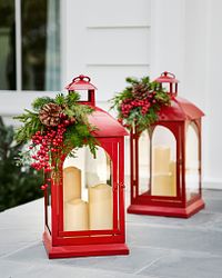 Two red Christmas lanterns with candles inside