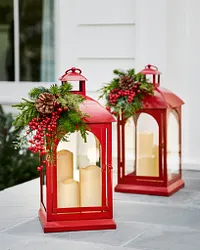 Two red Christmas lanterns with candles inside