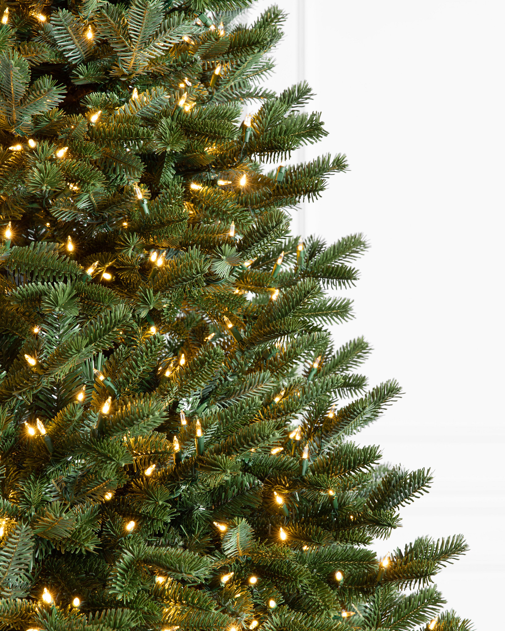 Gros plan d'un sapin de Noël artificiel avec des lumières DEL transparentes