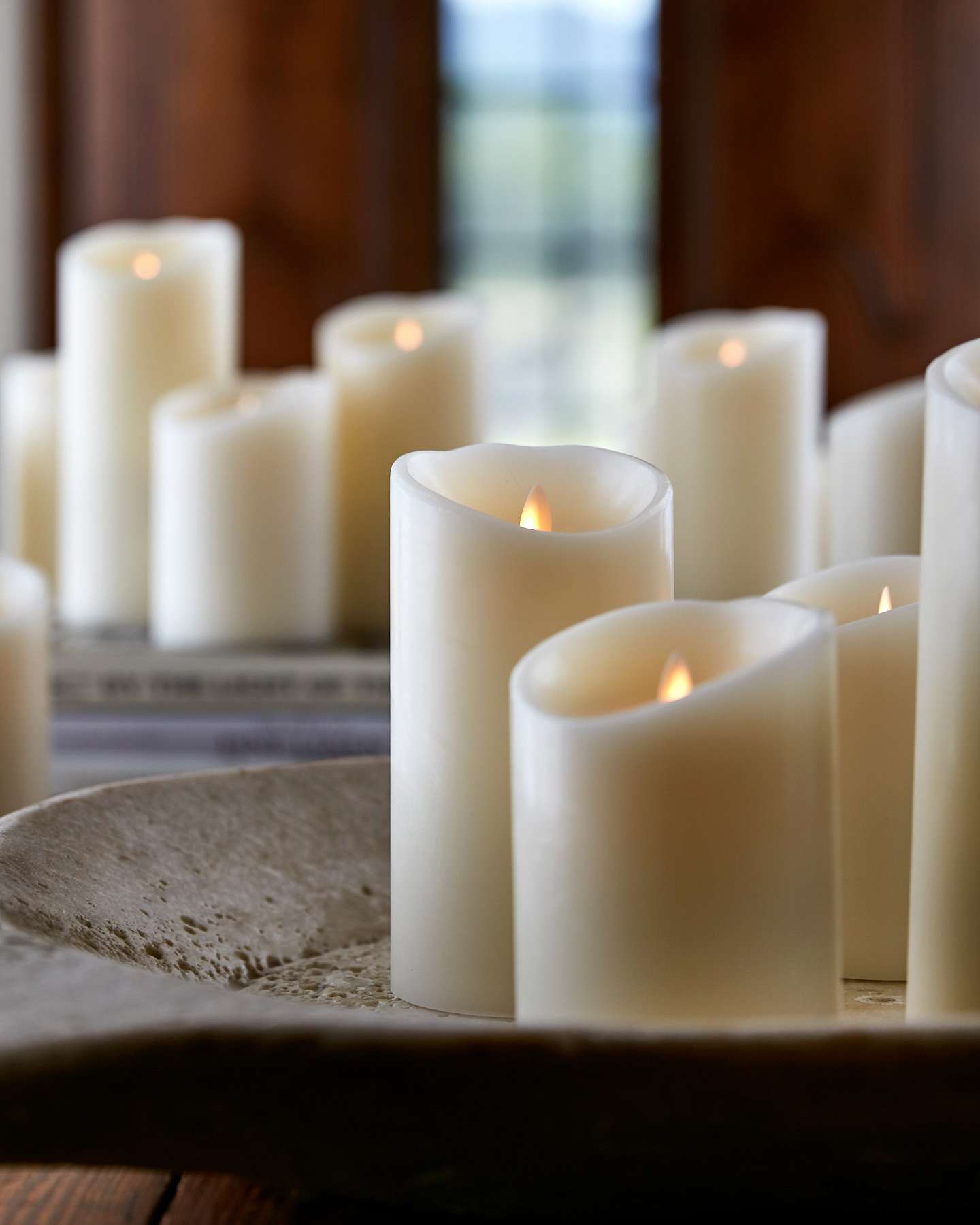 Balsam Hill Miracle Flame LED Wax Pillar Candle Displayed with Fresh Greenery