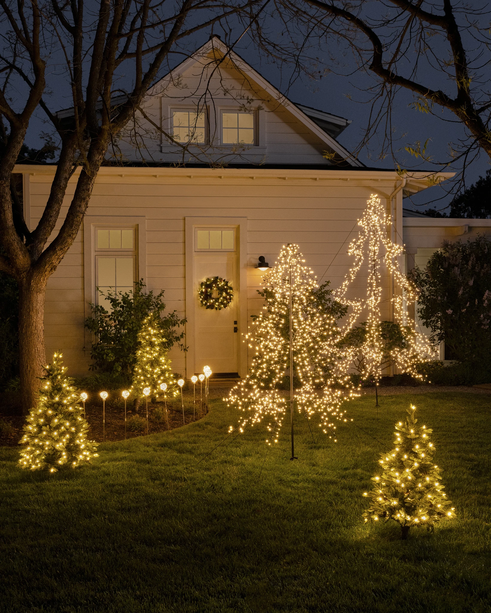 Christmas trees and lights outside the house at night