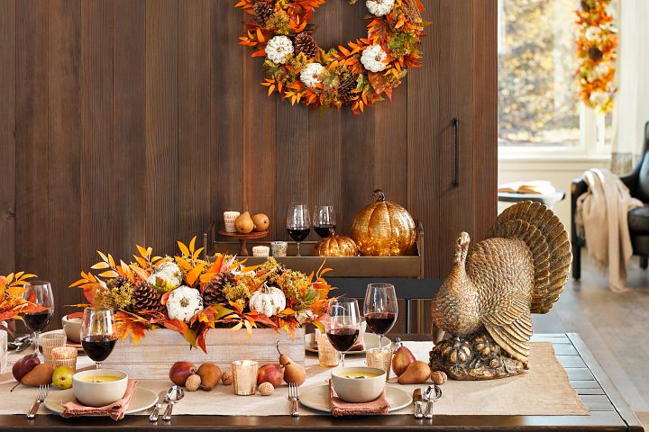 Thanksgiving dinner table decorated with artificial fall  foliage and bronzed turkey