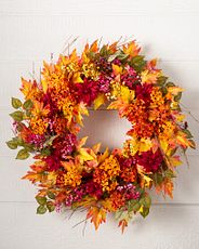 Fall wreath made with artificial magenta dahlias, orange wildflowers, and golden maple leaves