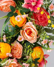 Closeup of artificial peonies and roses in orange and pink tones