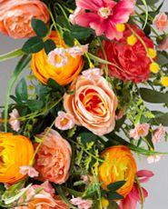 Closeup of artificial peonies and roses in orange and pink tones