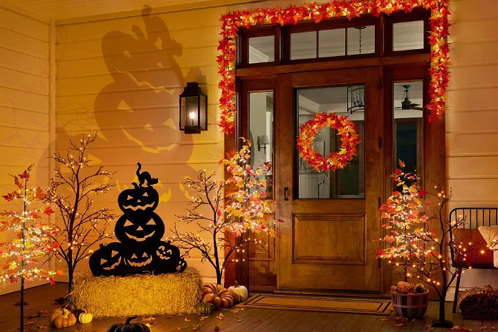 Entryway decorated with lighted garland, wreath, and Halloween décor