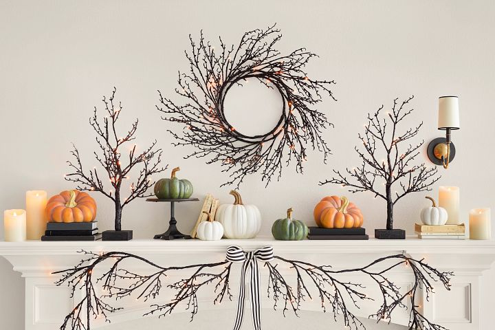 White mantel with twig wreath, pumpkins, and candles