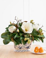 Artificial white magnolia flowers in a porcelain vase