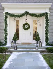 White front porch decorated with snowmen and Christmas greenery