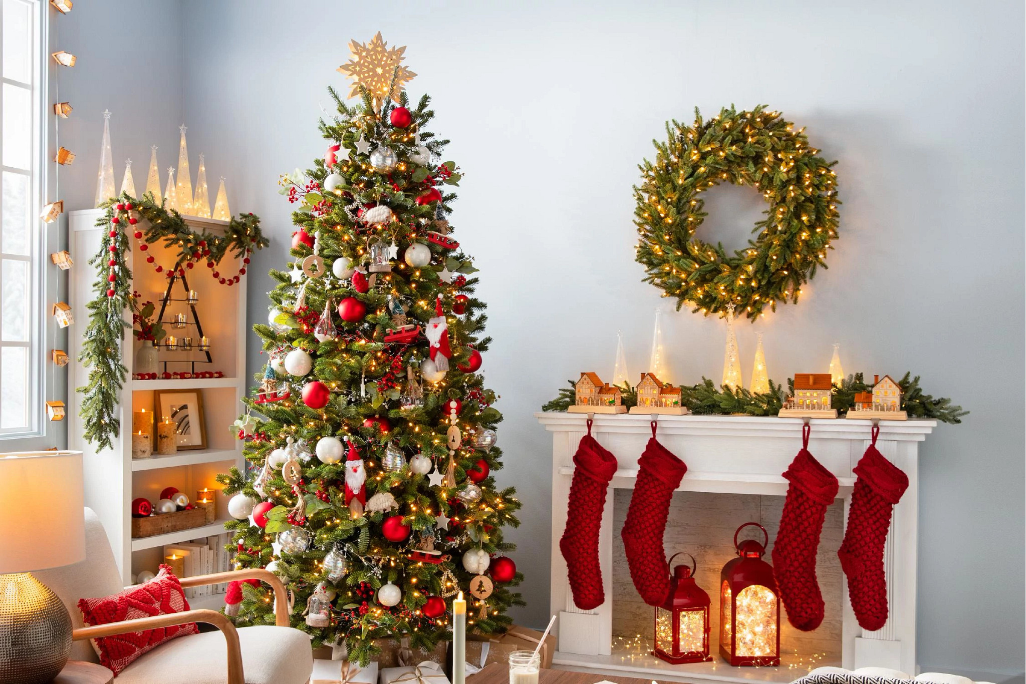 Artificial Christmas tree in living room next to fireplace decorated with red and white ornaments 