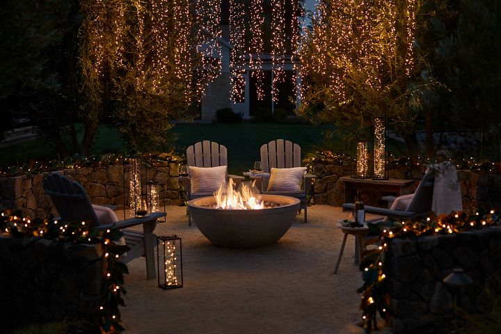 Outdoor firepit area with string lights and lanterns