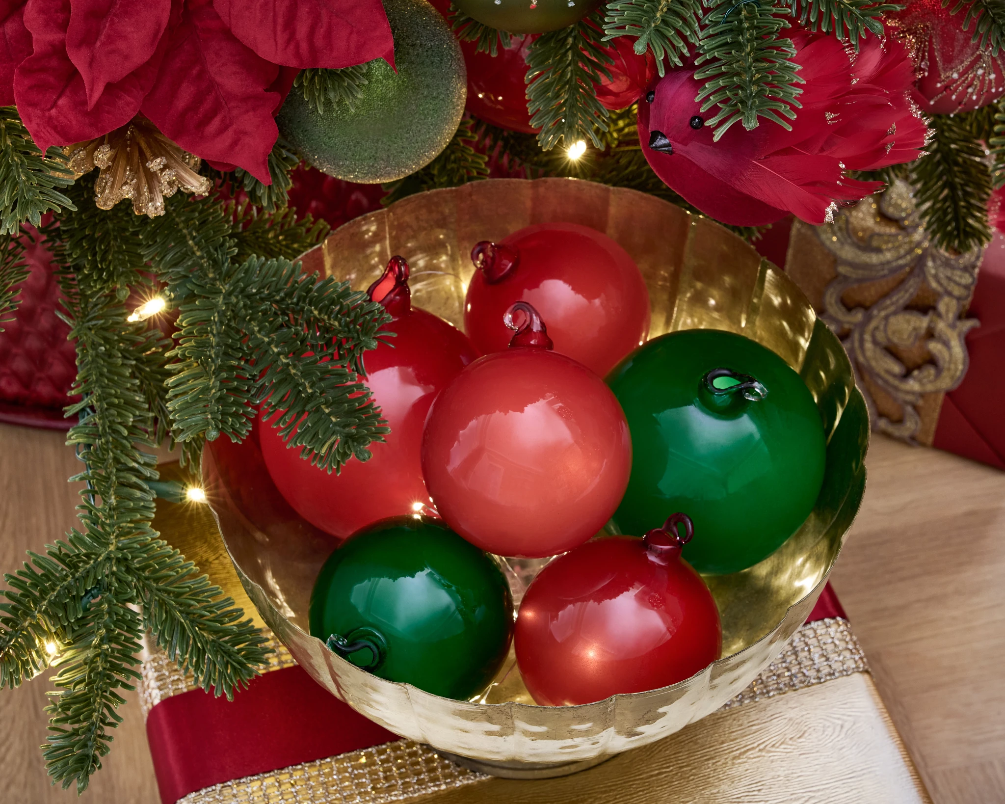 Red and green Christmas balls in a gold bowl
