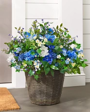 Artificial flowers and leaves in a brown basket