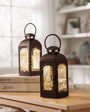 Pair of brown lanterns with LED fairy lights on a tabletop