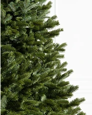 Close-up of artificial Christmas tree with realistic and traditional foliage