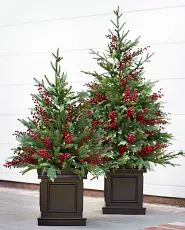 Zwei künstliche Mini-Weihnachtsbäume mit roten Beeren in braunen Pflanzkübeln