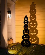 Pumpkin silhouette displayed against a wall and illuminated by orange light