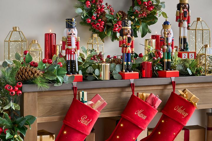 Christmas mantel decorated with nutcrackers and lit stockings