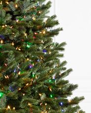 Close-up image of artificial Christmas tree with clear and multicolored lights.