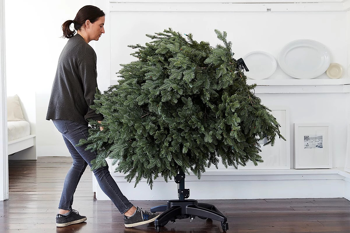 A woman flipping the base of a Flip Christmas tree