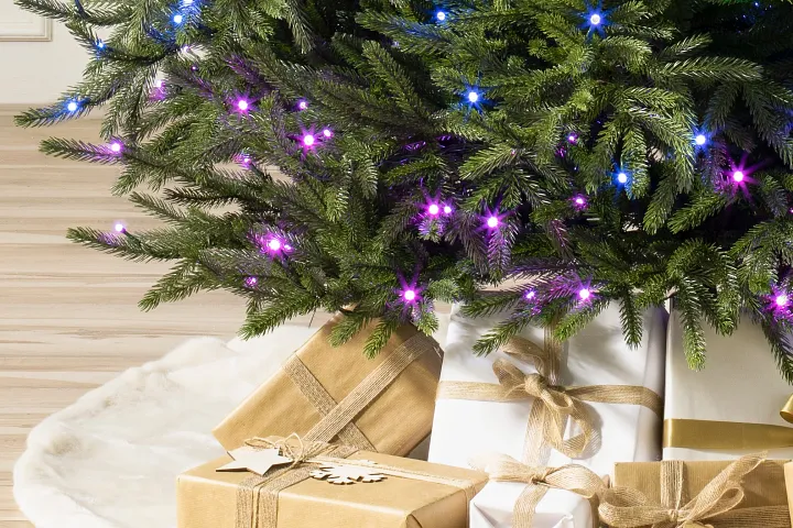 Bottom of Twinkly tree with wrapped gifts and fur tree skirt