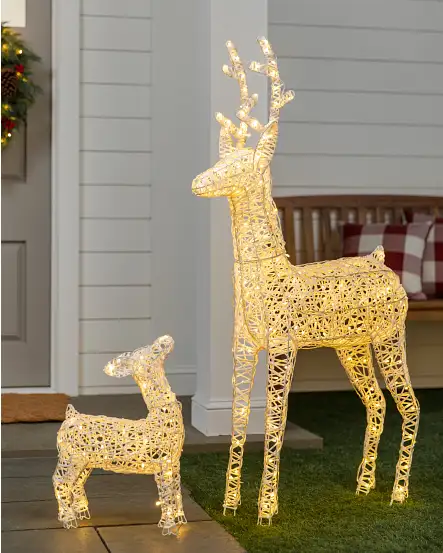 Beleuchtete Rentier- und Kitz-Weihnachtsdekoration auf einer Veranda im Freien.